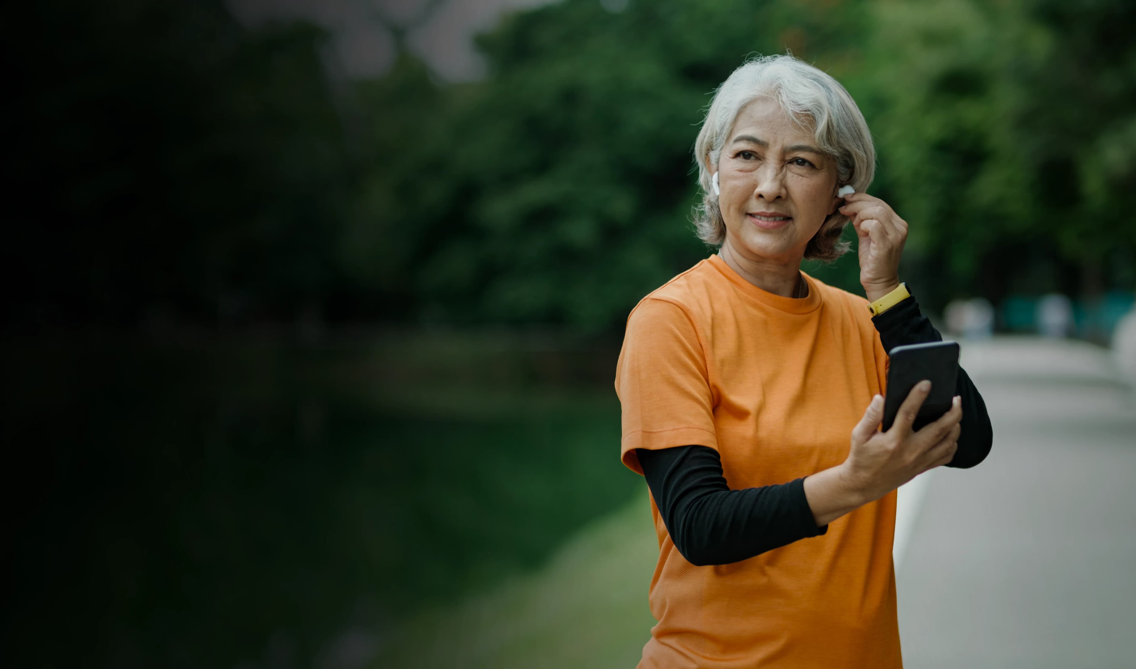 Athletic senior woman listening to music outdoors