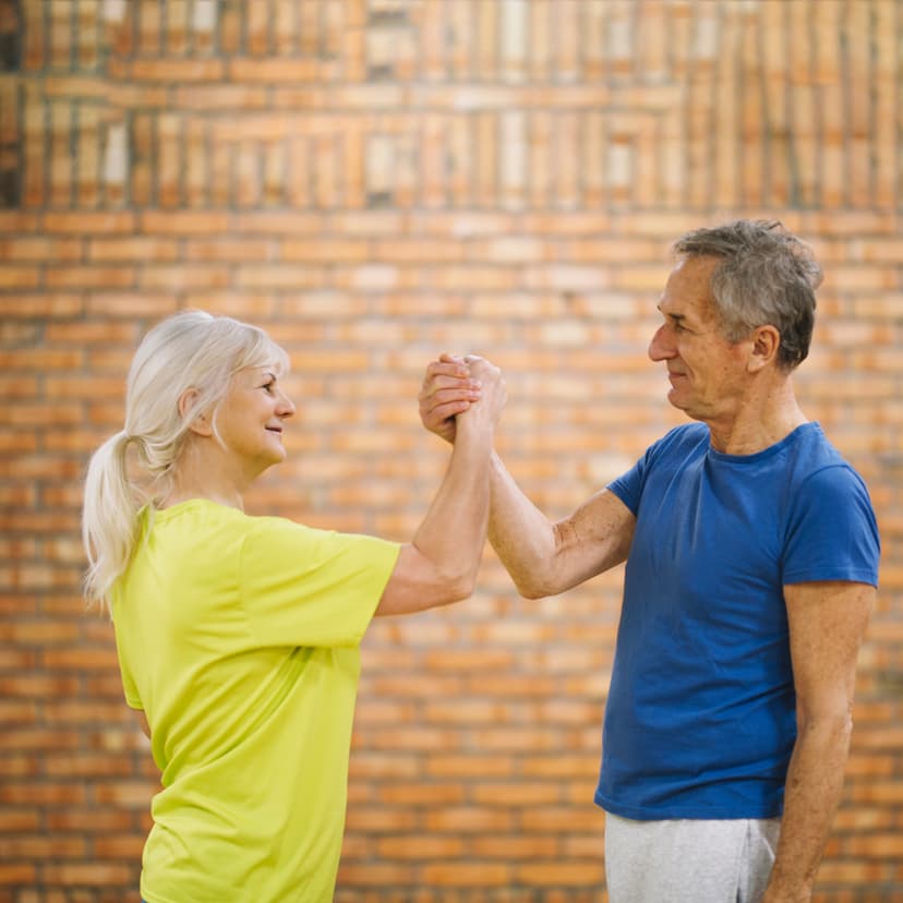 Smiling older couple shaking hands in gym